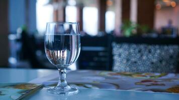 Fancy glass with water on blur gold lights bokeh background on the bar and hotel photo