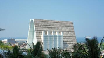 A triangular shaped architectural building with a background of blue sea and sky photo