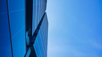 bottom view blue glasses building with sky and cloud background. Skyscraper, view of modern business building. mockup modern blue glasses building landscape. looking up perspective. Copy space photo