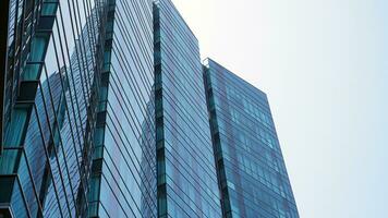 Blue glass building with sky and cloud background. Skyscraper, view of modern bussiness building. Sky view landscape with modern blue glasses building photo