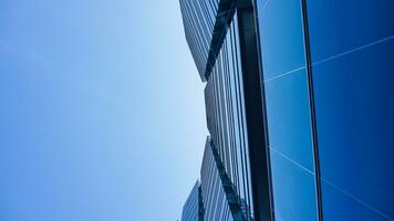 bottom view blue glasses building with sky and cloud background. Skyscraper, view of modern business building. mockup modern blue glasses building landscape. looking up perspective. Copy space photo