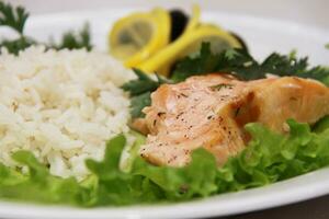 Freshly seared piece of salmon resting on a plate  with brown ri photo