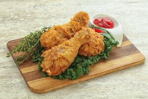 Fried chicken drumsticks with tomato sauce photo