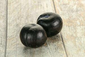 Two ripe sweet black plums photo