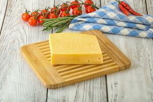 Piece of natural organic cheese over board photo