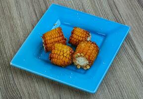 Grilled corn on wooden background photo