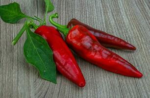 Red peppers on wooden background photo