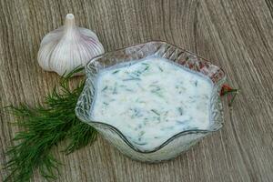 Tzatziki on wooden background photo