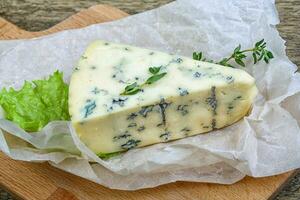 Blue cheese on wooden background photo