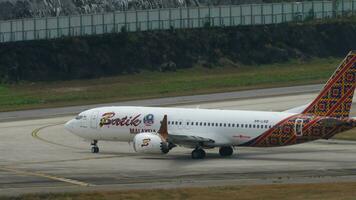 phuket, thailand februari 03, 2023 flygplan boeing 737, 9m lrd av batik luft malaysia taxning på phuket flygplats, sida se. passagerare flyg på landningsbanan. turism och resa begrepp video