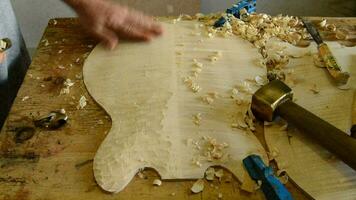 luthier arbetssätt på de topp av en böjd instrument video