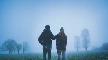 Lover women and men asians travel relax in the holiday. Happy to travel in the holiday. Lovers walk hand in hand on rice field. During the foggy winter photo