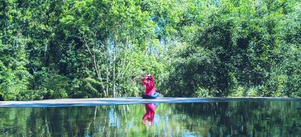 Young girl standing relaxing body, yoga exercise. Hot Springs In National Park,Hot Spring nature travel,Relax and exercise at the pool. photo