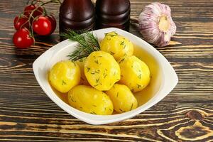 Boiled potato with oil and dill photo