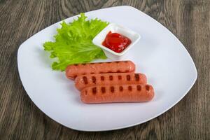 Grilled sausages over wooden photo