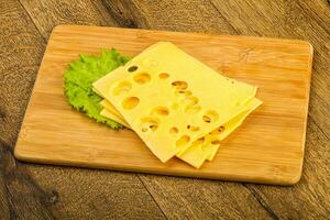 Sliced cheese over wooden photo