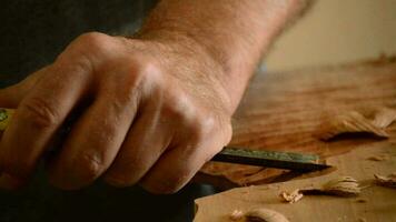 Luthier working with a chisel in workplace video