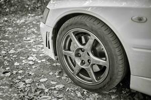 White car's wheel on a street background. Modern city sport car wheel wallpaper photo