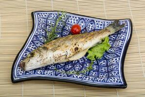 Grilled seabass over wooden photo