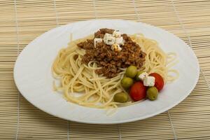 Bolognese pasta over wooden photo