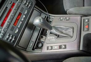 Shift lever, car steering wheel and sensors. Inside a modern car view, city car interior background photo