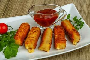 Cheese sticks over wooden photo