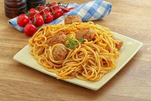 espaguetis con albóndigas en salsa de tomate foto