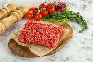 Raw minced beef meat on cutting board photo