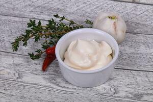 Mayonnaise sauce in the white bowl served thyme and garlic photo