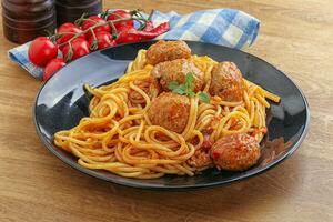 espaguetis con albóndigas en salsa de tomate foto