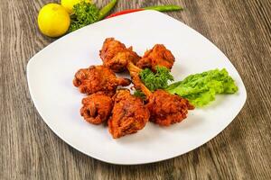 Chicken lollipops on wooden background photo