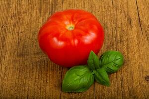 Tomato with basil leaves photo