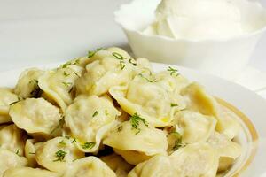 Bowl with traditional russian dish - pelmeni photo