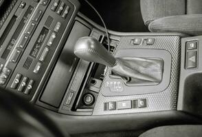 Shift lever, car steering wheel and sensors. Inside a modern car view, city car interior background photo