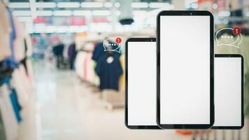 White screen smartphone with message icons isolated on background inside shopping mall. online shopping Website, marketplace platform, e-commerce technology and online payment concepts. photo