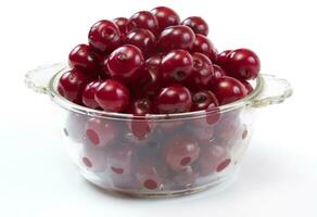 Bowl with ripe cherries. Isolated on a white background. photo