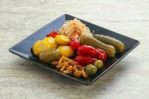 Plate with pickled vegetables and mushrooms photo