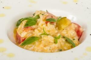 photo of delicious risotto dish with herbs and tomato on white background