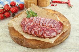 Sliced salami sausages over board photo