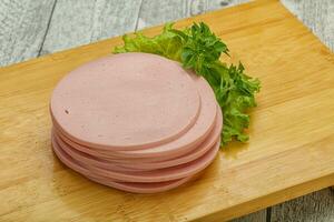 Sliced pork natural sausages over board photo