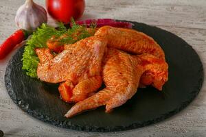 Raw marinated chicken wings photo