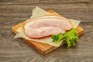 Sliced pork belly over board photo