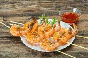 Grilled prawn skewer with sauce photo