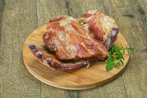 Smoked pork ribs over the wooden background photo