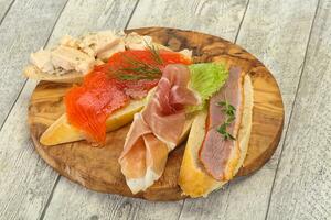 Tapas - bruschetta with prosciutto, salmon, duck and gorgonzola photo