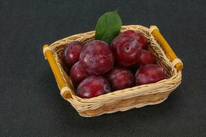 Plum heap in the wooden basket photo