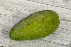 Green tasty mango over wooden background photo