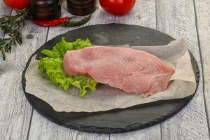 Raw Turkey steak served rosemary photo
