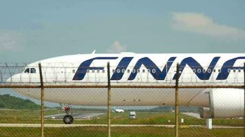 PHUKET, THAILAND NOVEMBER 26, 2016 Side view of FinnAir aircraft taxiing at Phuket airport. Passenger plane on the taxiway, middle shot video