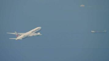 HONG KONG NOVEMBER 09, 2019 Commercial modern plane Boeing 777 of Japan Airlines taking off and climbing at Hong Kong airport, side view. Passenger flight departure video